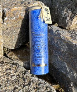 Hellblaue Visuddha Chakra Kerze auf Steinen im Freien