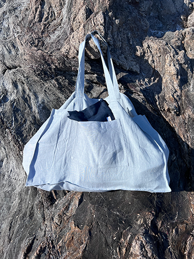 Leinen Strandtasche Ice Blue hängend am Felsen
