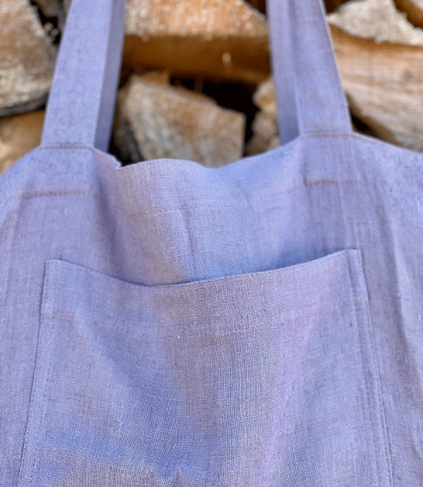 Detailaufnahme pastell lila Strandtasche aus europäischem Leinen von Linen Couture vor Holz hängend