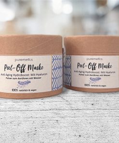 Zwei Papierdosen mit Peel-Off Maske Anti-Aging von Puremetics, Pulver zum Anrühren, auf Betonboden