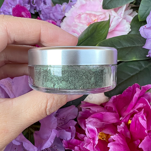 Grüner Angel Minerals Malachit Glossy Eyeshadow zwischen Blüten