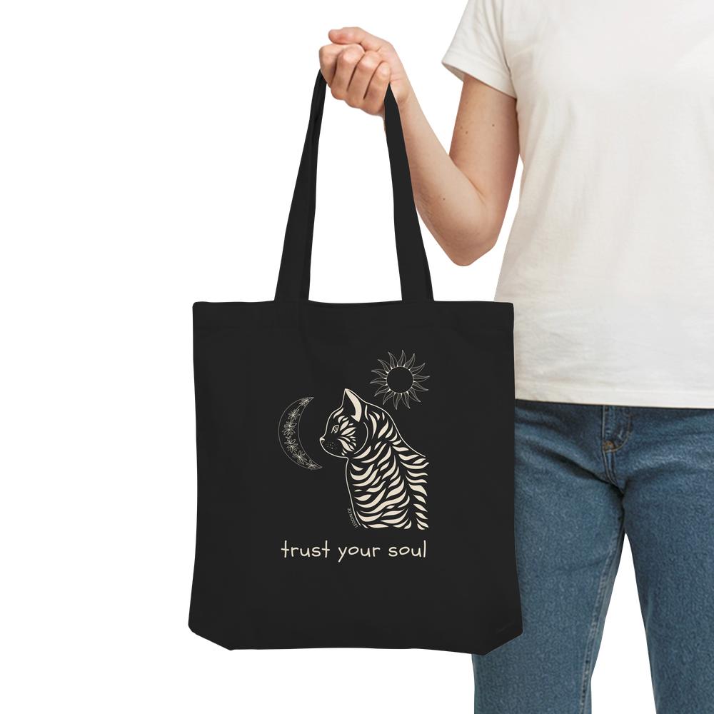 Person trägt schwarze Katzen Stofftasche mit spirituellem Katzenmotiv
