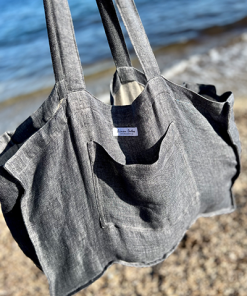 Graue Leinen Strandtasche frei hängend vor dem Meer