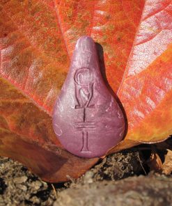 Stein der Harmonie in Flieder vor einem herbstlichen Blatt