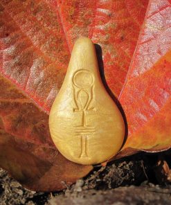 Stein der Harmonie in Gold vor einem herbstlichen Blatt