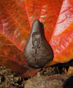 Stein der Harmonie in Goldschwarz vor einem herbstlichen Blatt