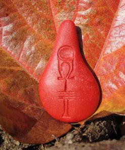Stein der Harmonie in Korallrot vor einem herbstlichen Blatt