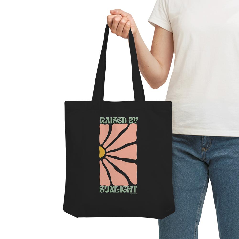 Frau trägt schwarze Raised by Sunlight Tote Bag