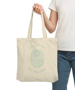 Frau trägt naturfarbene Meer Tote Bag mit Let the Sea Set You Free Print